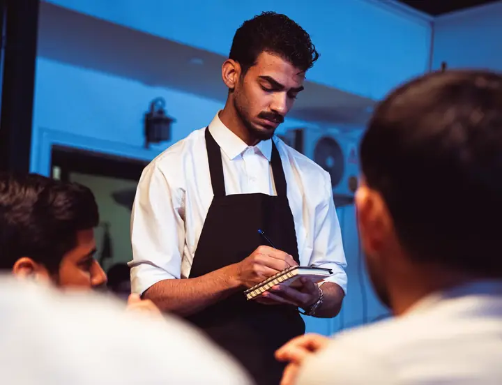 Barista melayani pelanggan di meja bar