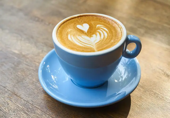 Secangkir kopi dengan latte art rosetta